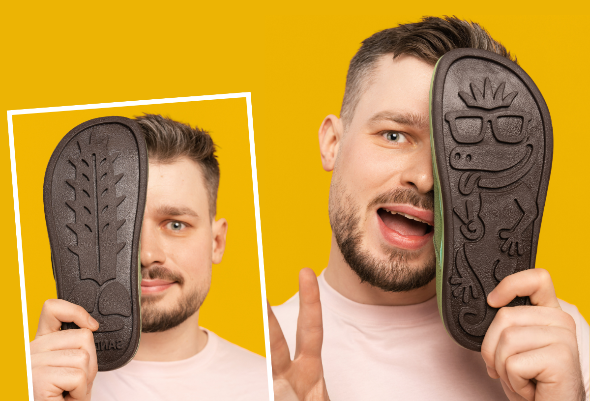 Man holding Sand-U sandals showing soles with unique designs 